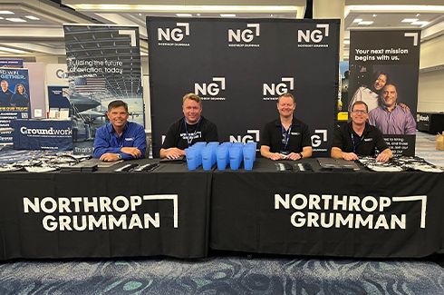 people sitting at northrop grumman table at event