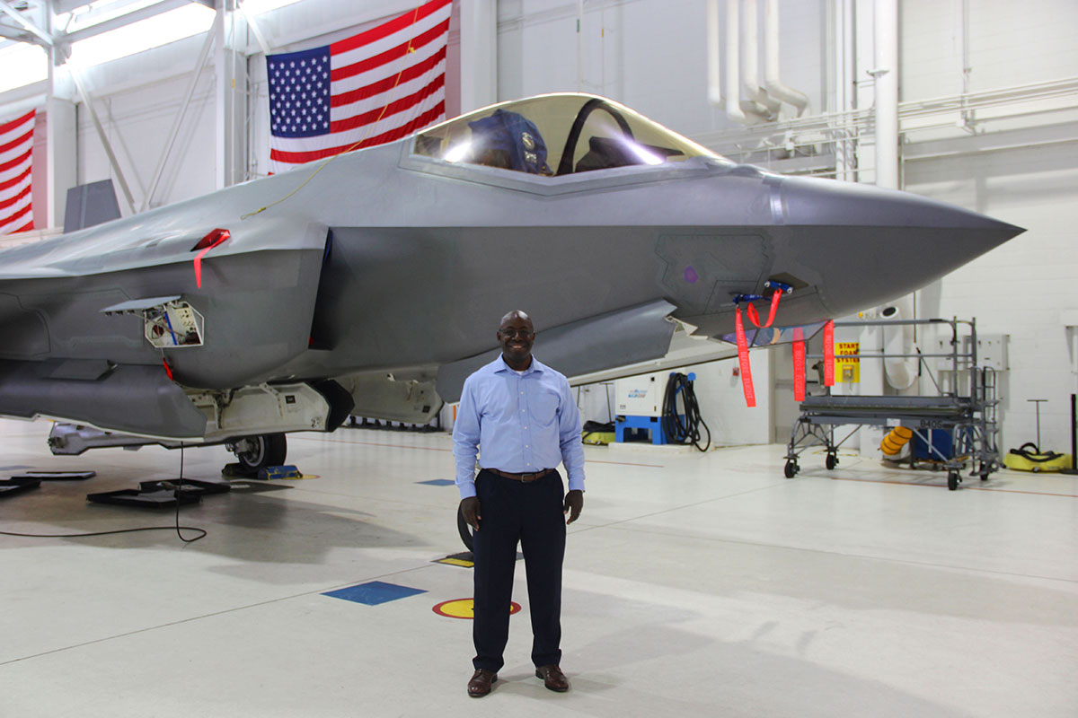 man standing in front of fighter jet