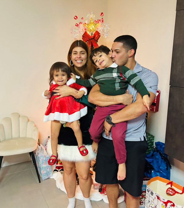 family of 4 in front of christmas tree