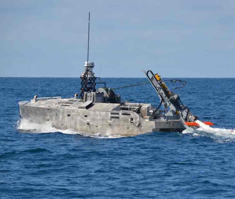 AQS-24B minehunting system launched from an unmanned surface vehicle, operating in open water with crew and equipment visible.