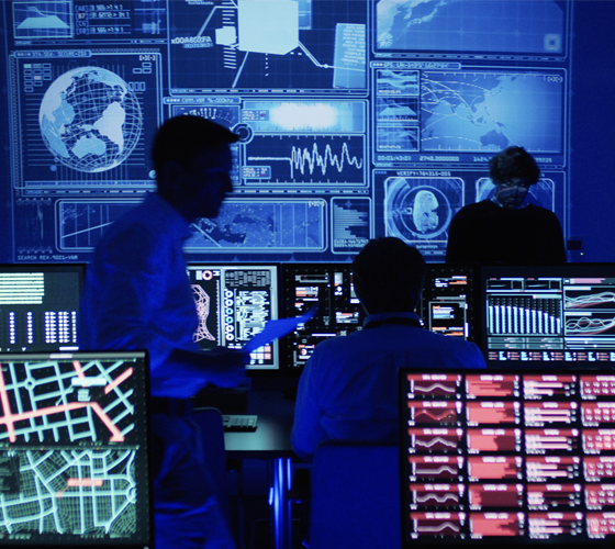 Image of computers and displays lit up in dark room