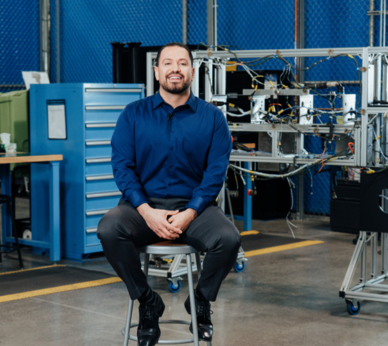 man on stool in workshop smiling