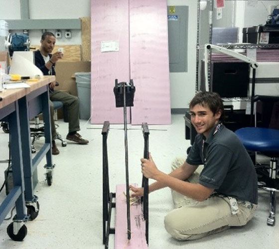 student working on catapult in engineering lab