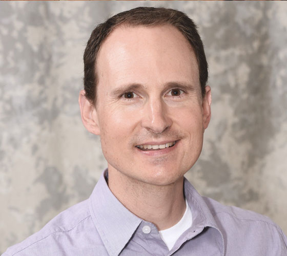 Photo of man in dress shirt smiling
