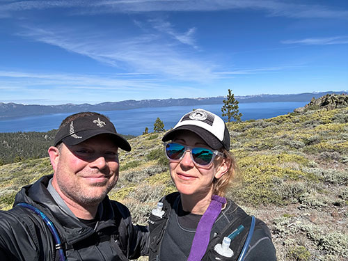 photo of man and woman with lake tahoe in background