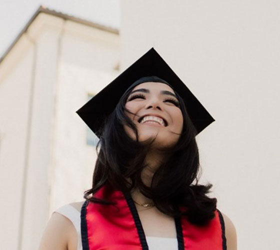 woman smiling in graduation regalia
