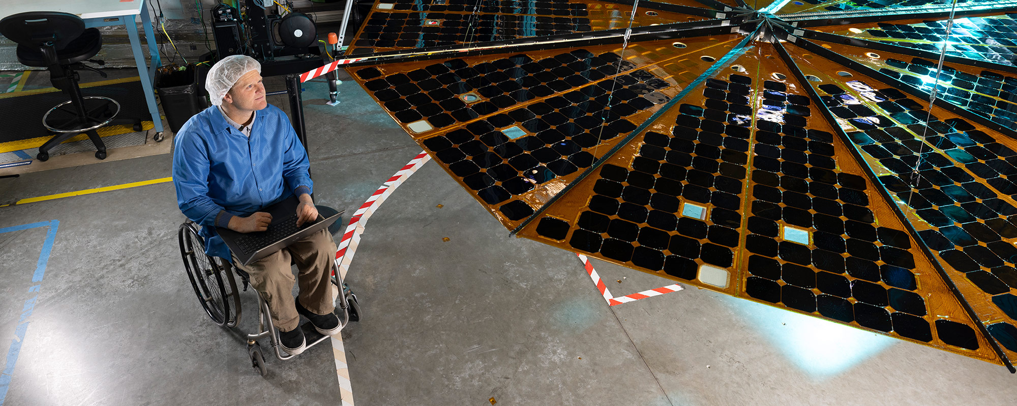 man in wheelchair looking at solar array