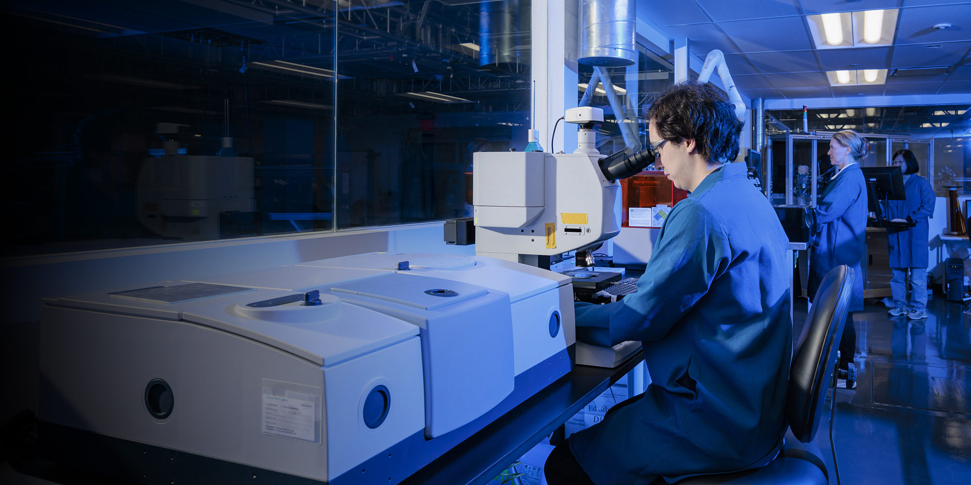 people working in a research lab with blue coats