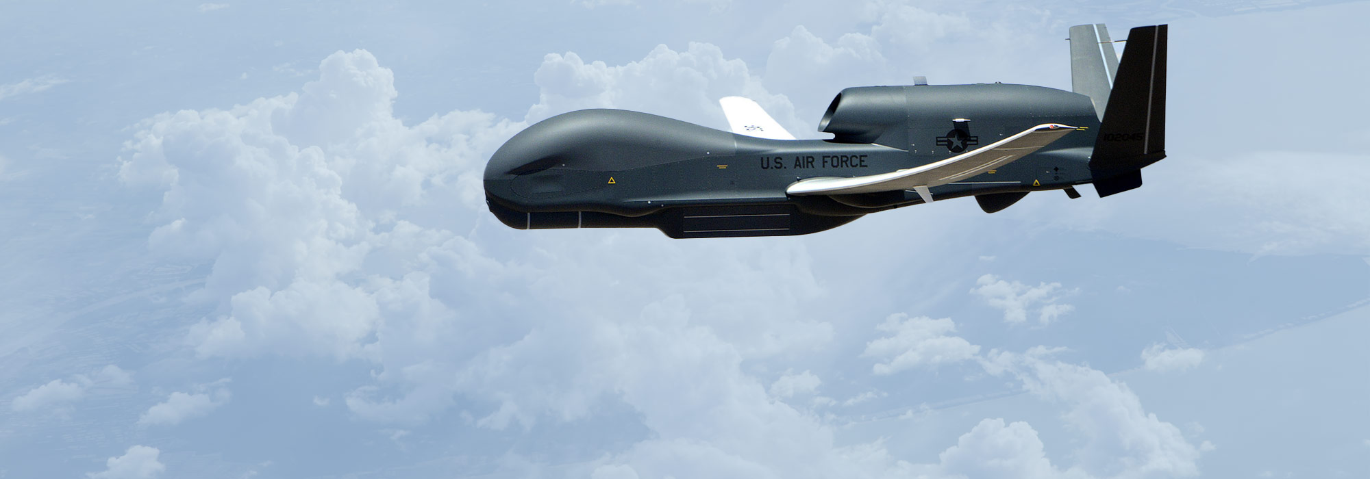 Global Hawk unmanned aircraft flying above clouds