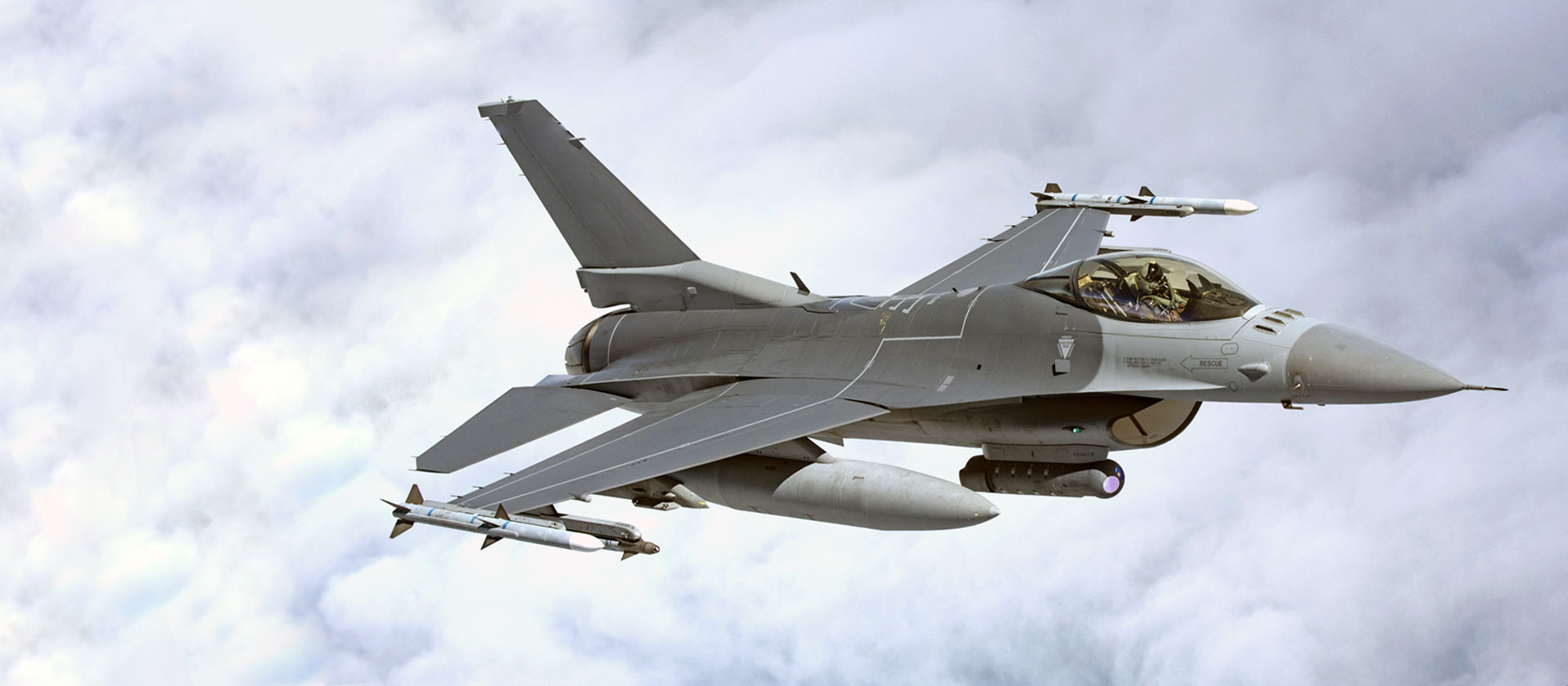 f-16 in flight above the clouds