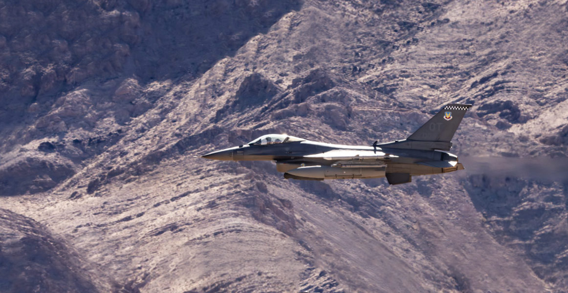 Integrated Viper Electronic Warfare Suite (IVEWS) F-16 fighter jet flying over mountains