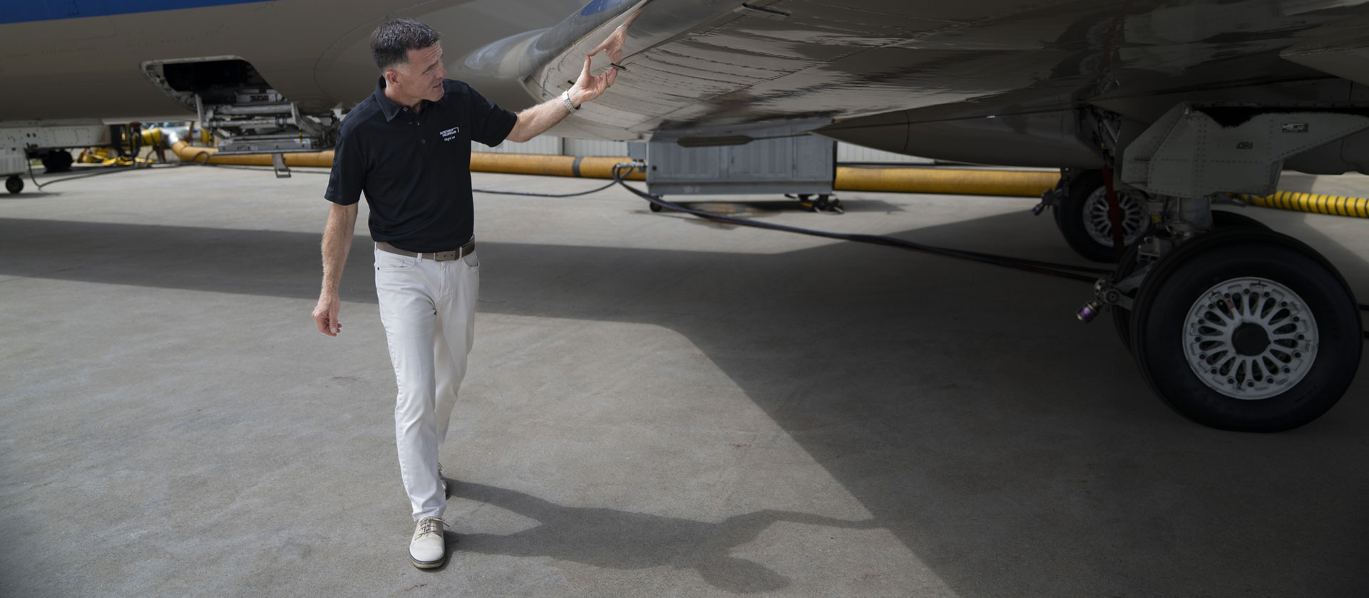 pilot walking below aircraft wing