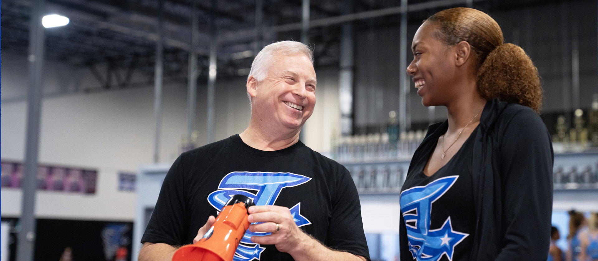 Coaches smile at each other during sporting event.