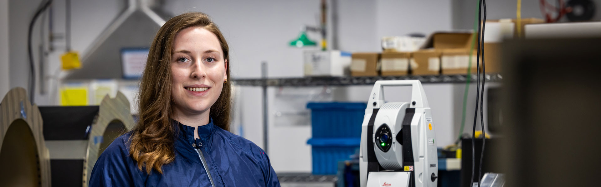 image of woman in lab with blue labcoat smiling