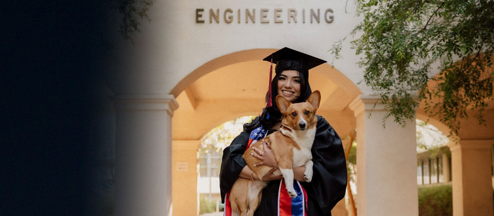 woman in graduation regalia holding dog