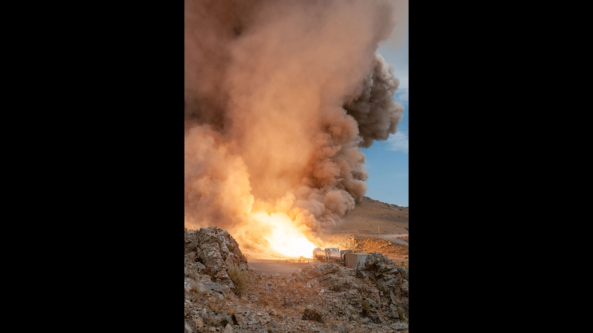 Artemis I – Flight Support Booster-2 Test: Northrop Grumman static test fires a full-scale SLS booster at its Promontory, Utah, facility rocket test in desert with smoke in the sky