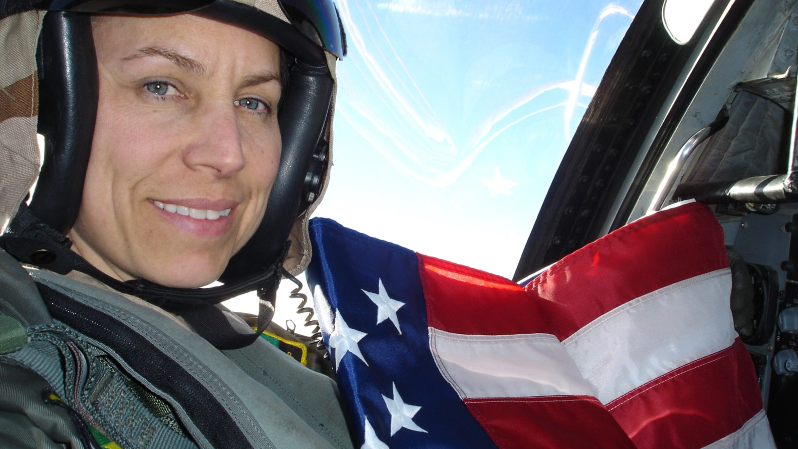 First Female Aviator Assigned to her Navy Squadron Now Leads at Northrop Grumman white woman fighter pilot holding flag