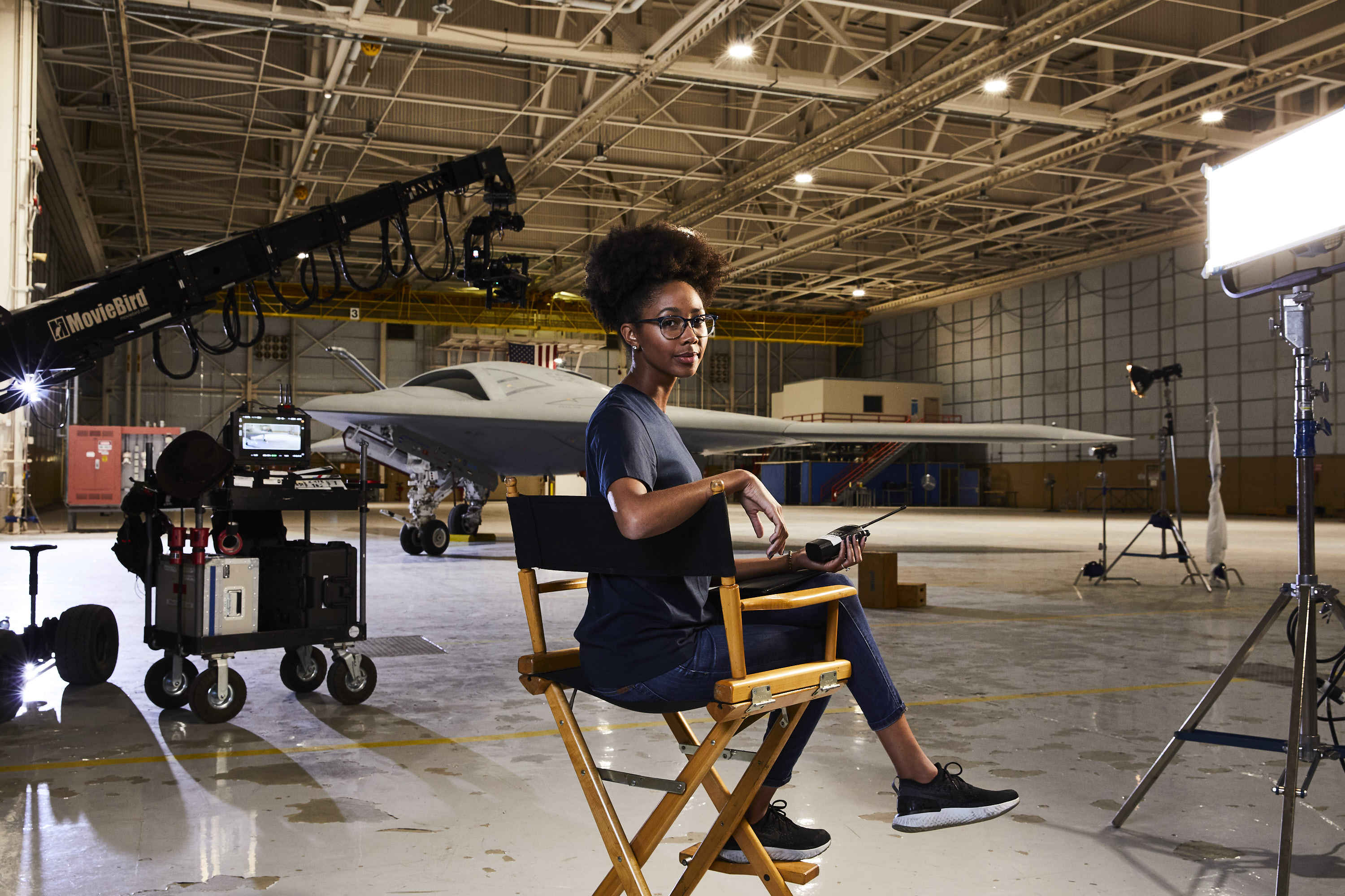 Laila Yette Female sitting in director style chair in hangar