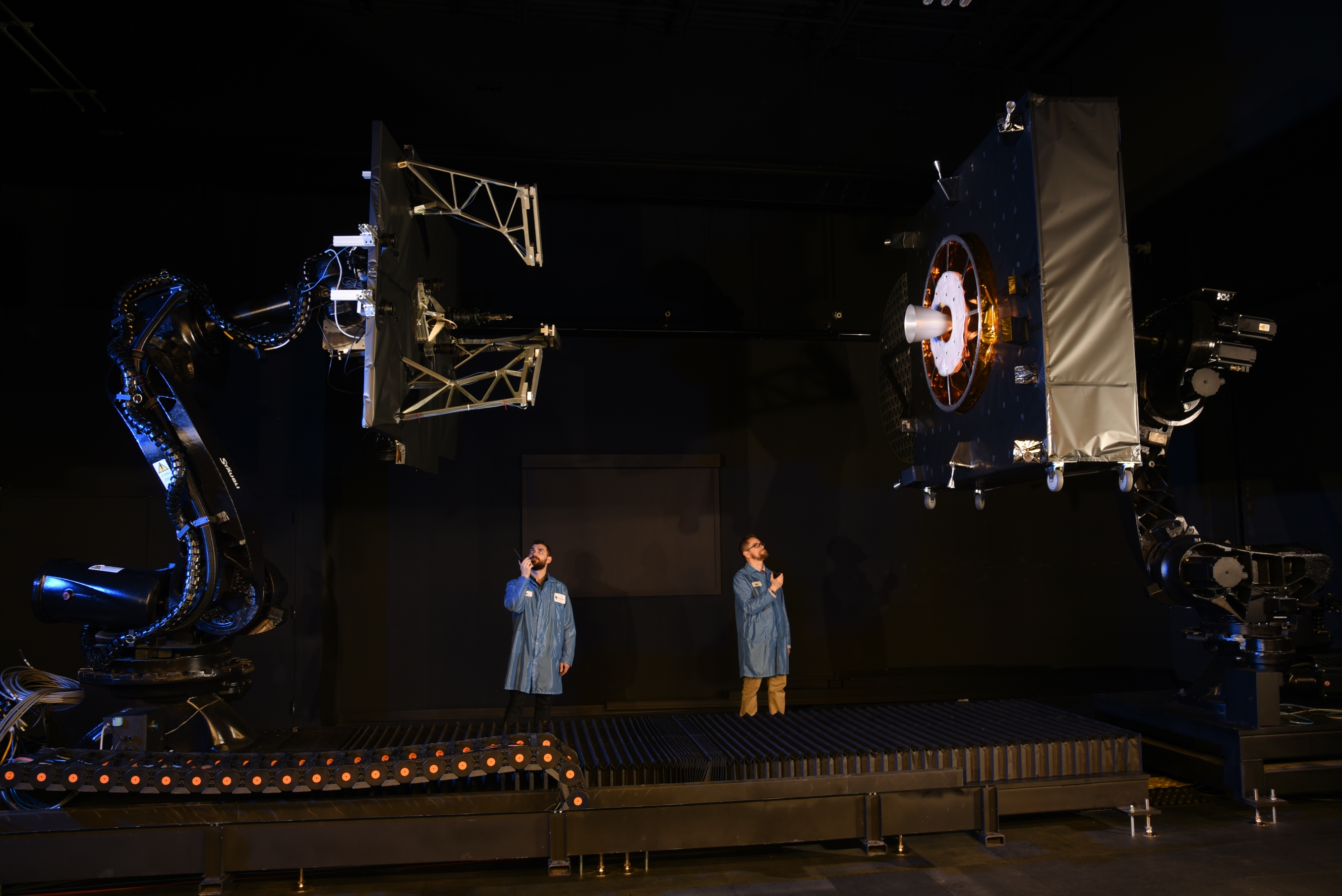 two technicians in proximity operations lab with model spacecraft